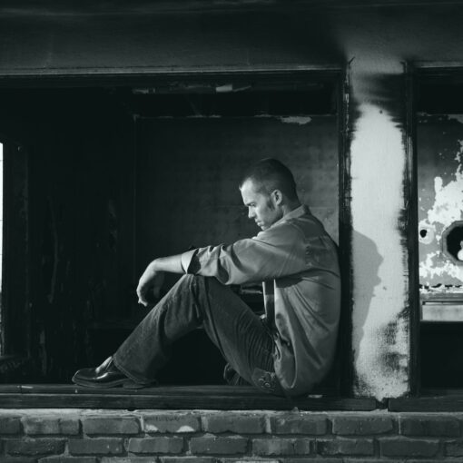 grayscale photo of man sitting