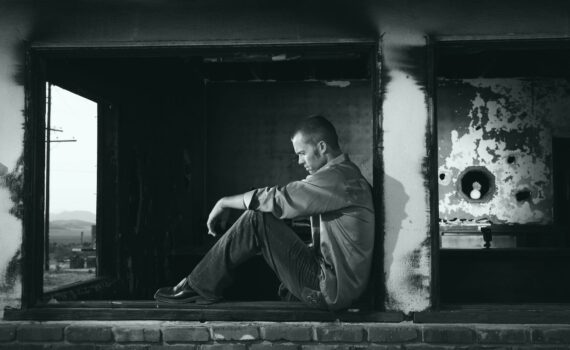 grayscale photo of man sitting