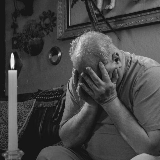 grayscale photo of man covering his face with hands