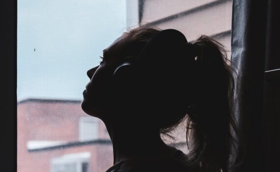 silhouette photo of a woman looking through window