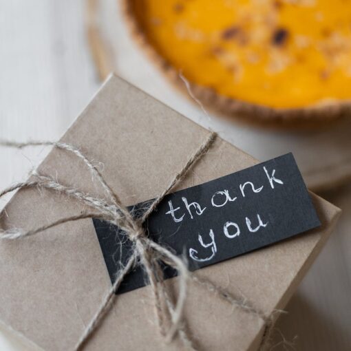 carton gift box with postcard on table near pie