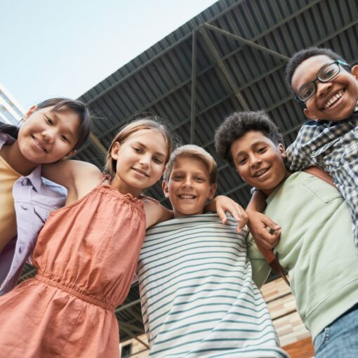 kids arms around each other while smiling at the camera