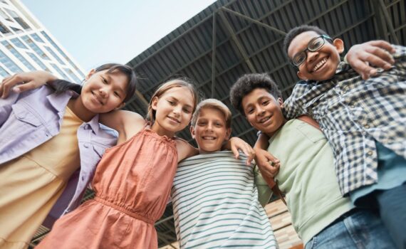 kids arms around each other while smiling at the camera