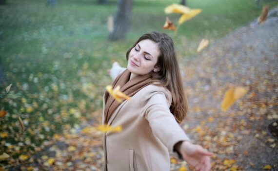 woman open arms while closed eyes smiling photo