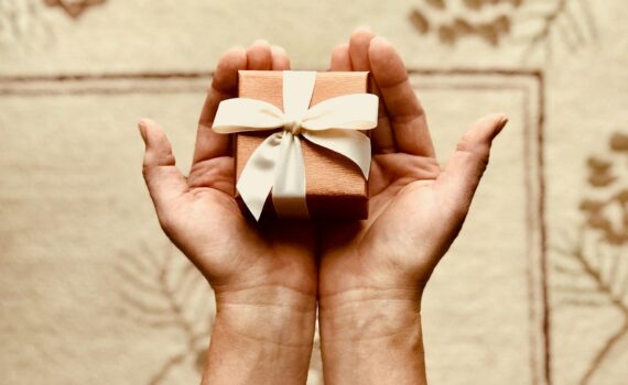 person s holds brown gift box