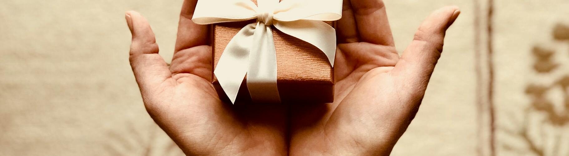 person s holds brown gift box