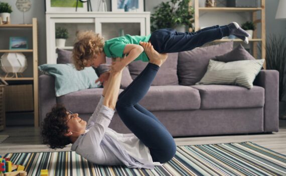woman lying down and playing with son