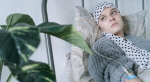 a woman wearing headscarf having a treatment while lying on hospital bed