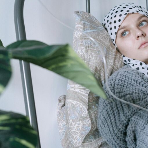 a woman wearing headscarf having a treatment while lying on hospital bed