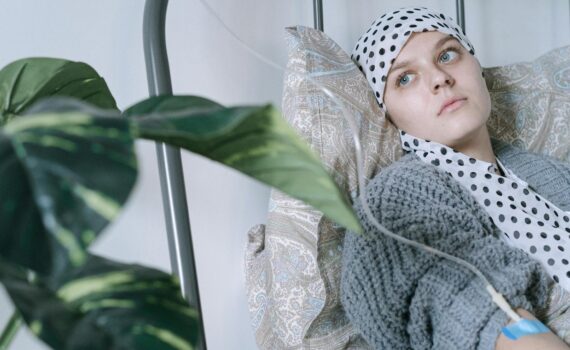 a woman wearing headscarf having a treatment while lying on hospital bed